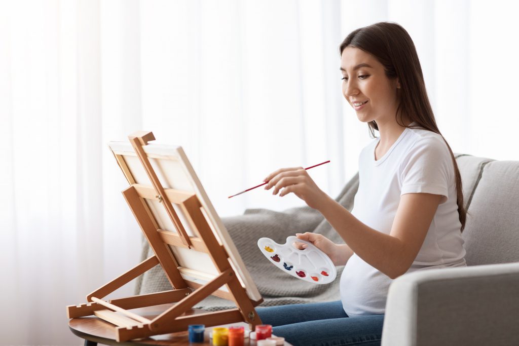 pregnant women painting on canvas