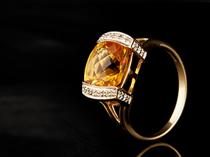 Yellow stone ring with diamonds on side