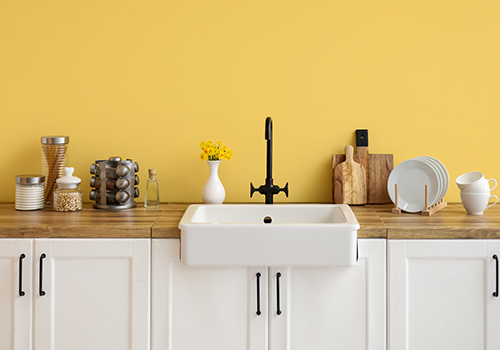 Yellow Wall Accenting The Sink Area In Kitchen